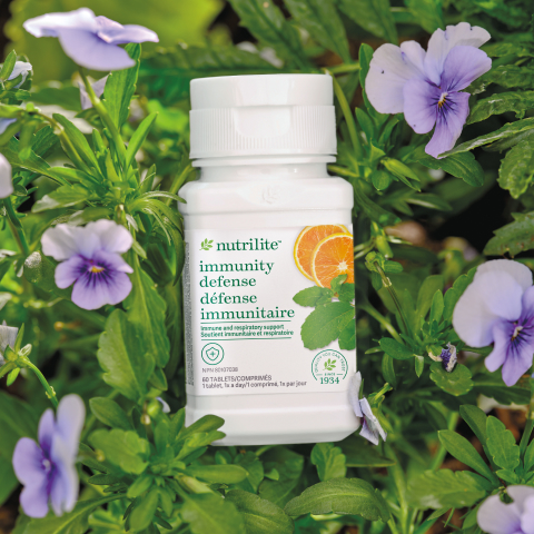 Nutrilite Immunity Defense product on a bed of pansies